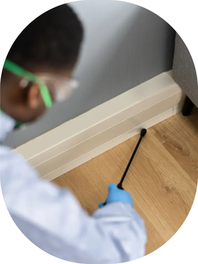 worker spraying base boards